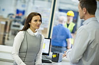 Brother PT-P900W label printer on desk with two people talking