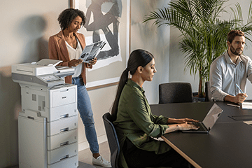 Business people gather around a Brother mono laser printer