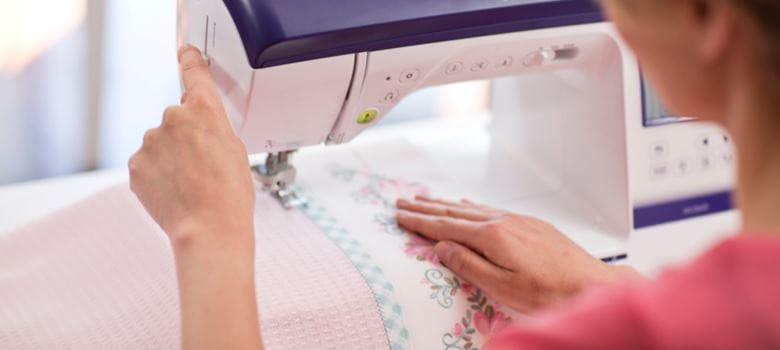 woman sewing material on sewing machine