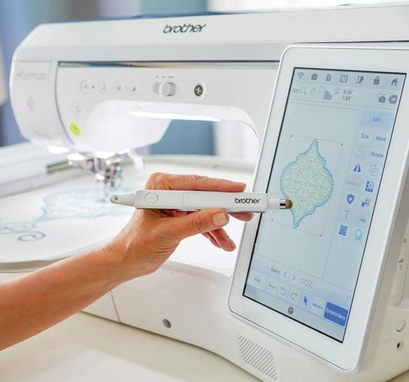 Persons hand using a sewing machine touchscreen with stylus pen